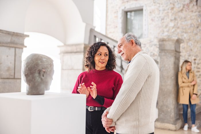 man and woman discussing a sculpture in a museum