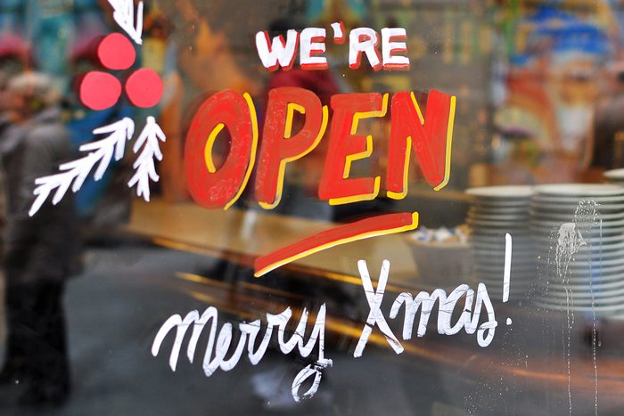 painted glass that says "we're open merry xmas"