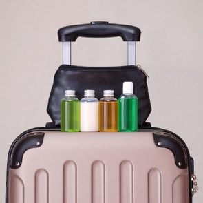 travel toiletries, small plastic bottles of hygiene products on the suitcase