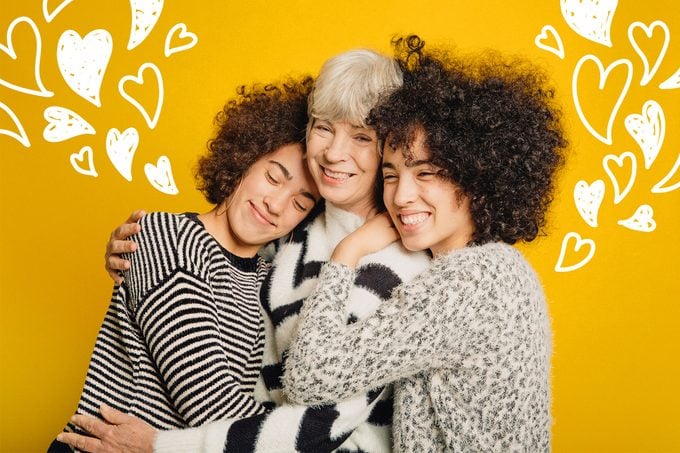 Teenage twins embracing their mother on a yellow background. Doodles of hearts on each side