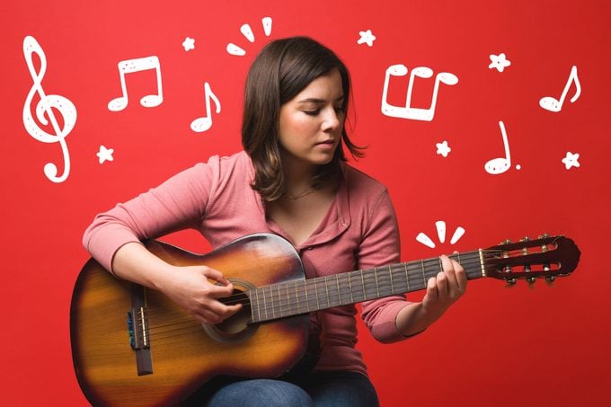 Woman practicing guitar, music doodles