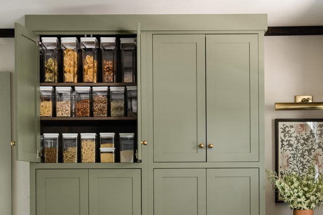 clear storage containers for pantry items in a green cabinet