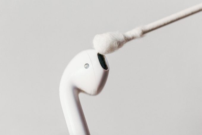 close up cleaning AirPod with cotton swab