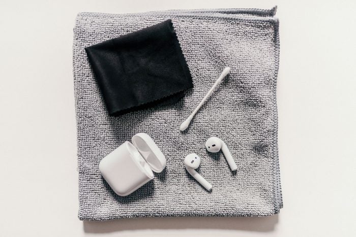 AirPods and cleaning supplies from above on white table