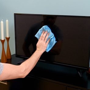 cleaning flat screen tv with blue cloth