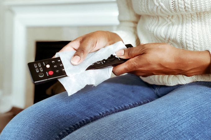 hands cleaning tv remote