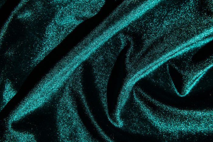 Texture of velour fabric is emerald green.