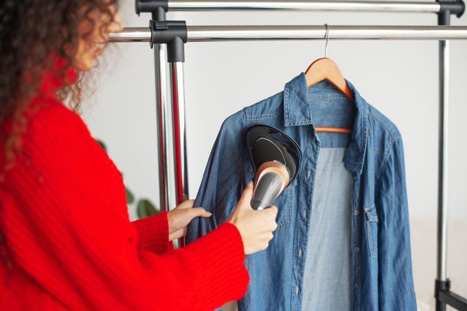woman steaming a jean button shirt