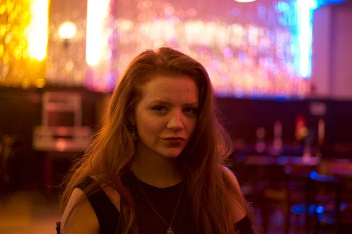 portrait of a redhead woman in a bar at night