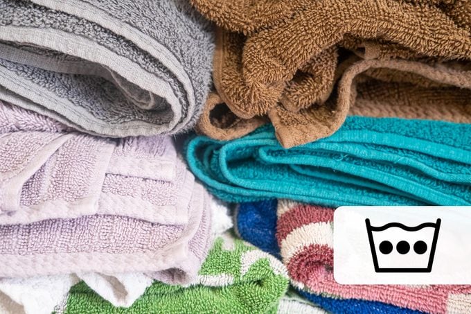 Stack of clean folded towels with a hot water laundry symbol