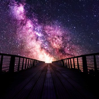 silhouette of a bridge path that leads to a purple cosmic sky with stars