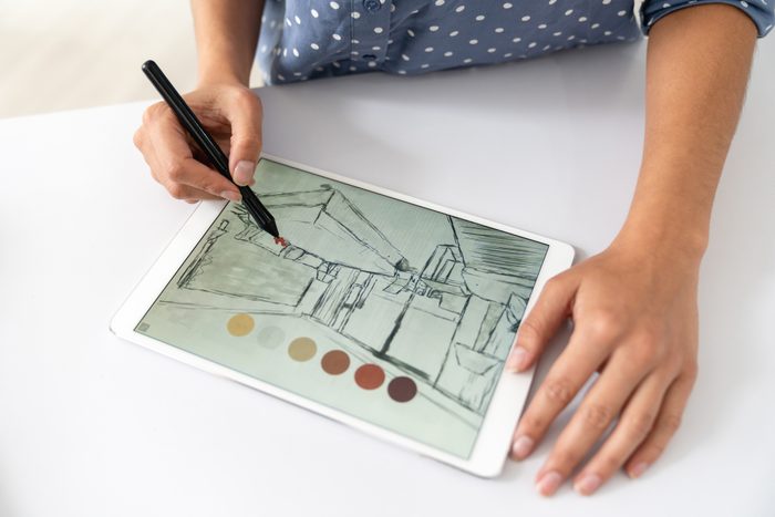 Close-up on an interior designer drawing a sketch on a digital tablet
