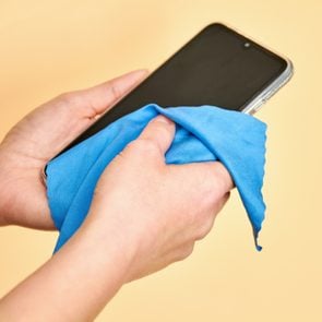 Female hands cleaning Mobile Phone for Covid-19 disease prevention. Virus prevention.