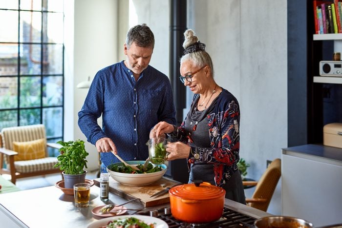 Mature man and senior woman making lunch
