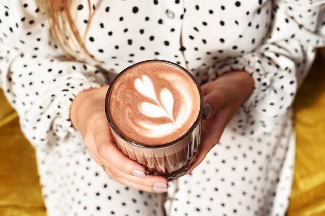 holding latte with a heart design