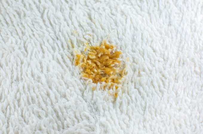 Dirty curry stain on white cotton towel or carpet. Close up photo.
