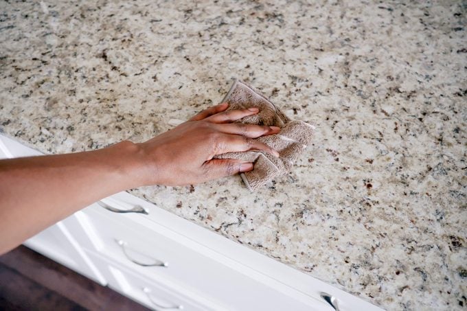 hand using a rag to clean the counter