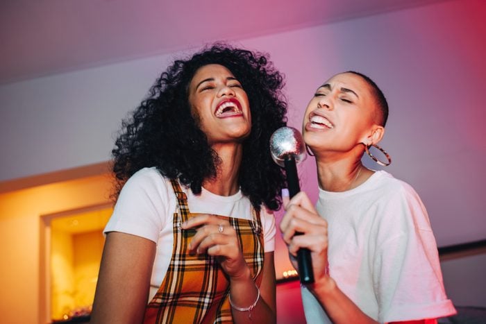 girlfriends singing into a microphone on karaoke night