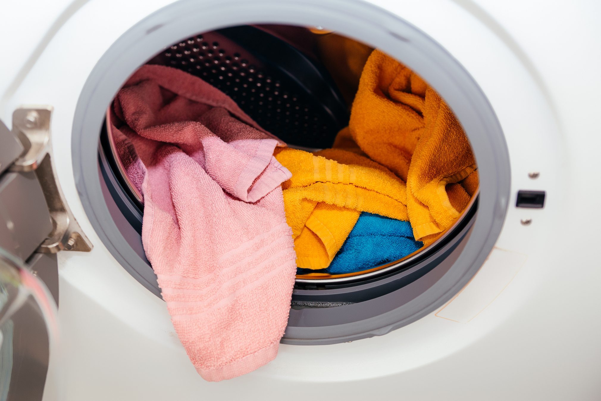 Colored towels in an open washing machine.