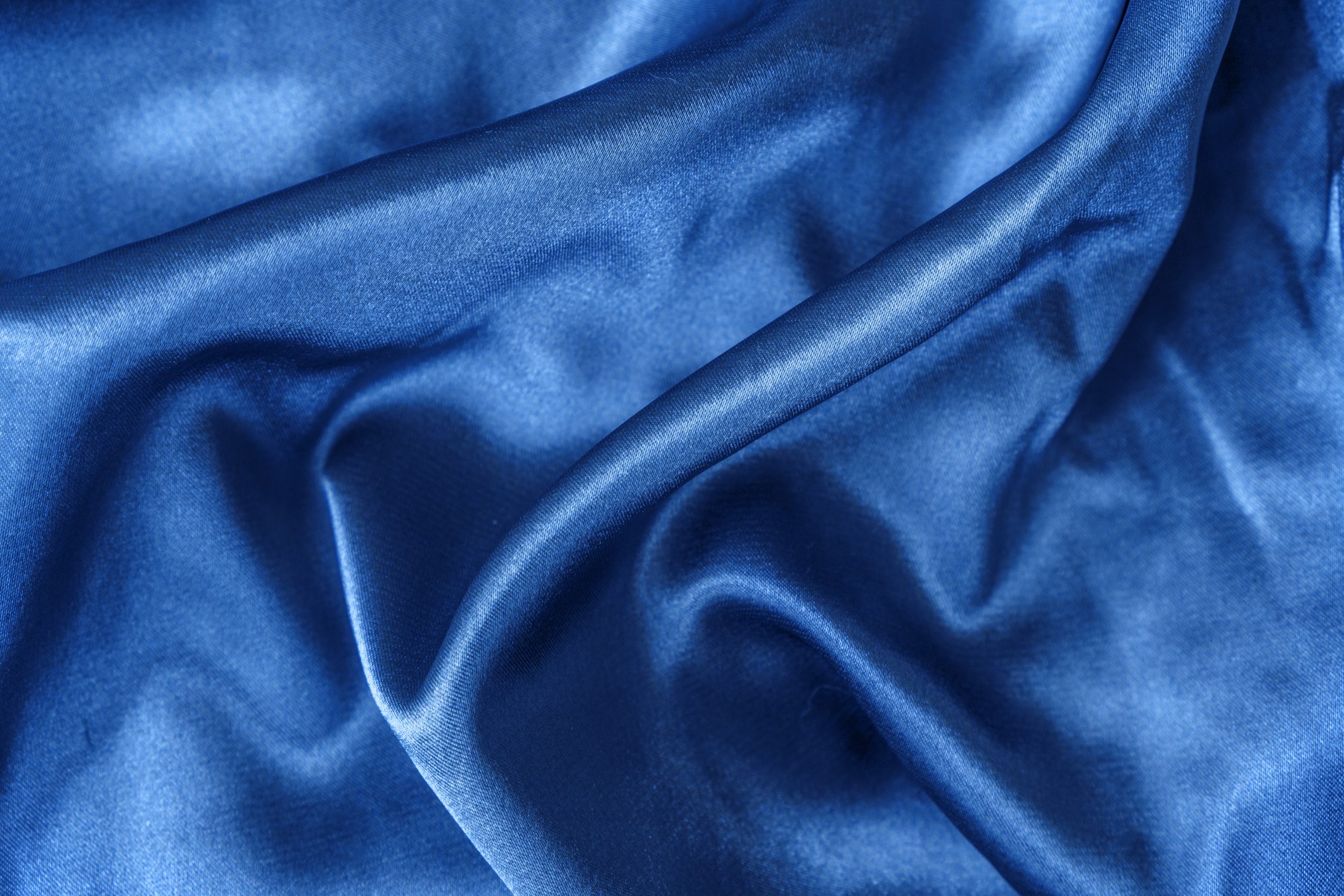 Elegant smooth blue silk or satin folds closeup Cloth texture