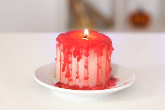 dripping candle onto a glass candle holder plate
