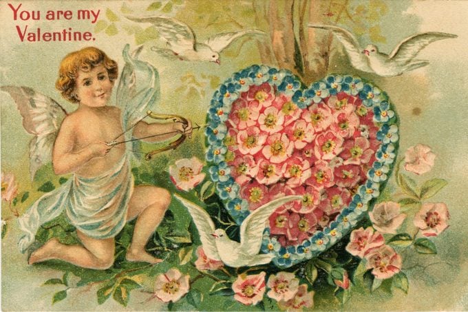 A Valentine's Day card depicting Cupid shooting an arrow into a floral heart