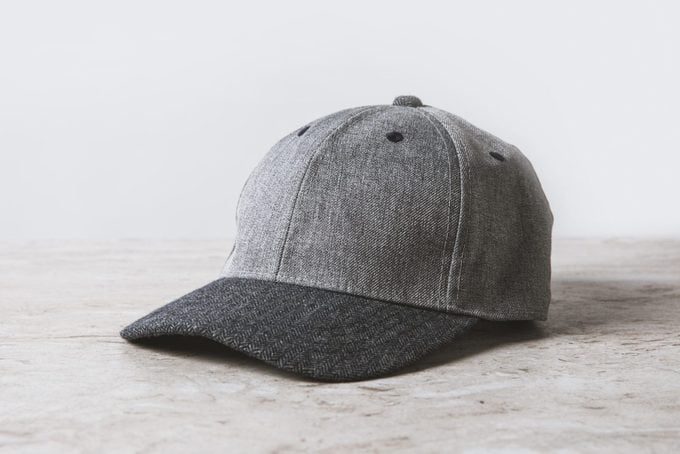 one grey cap on wooden table on white