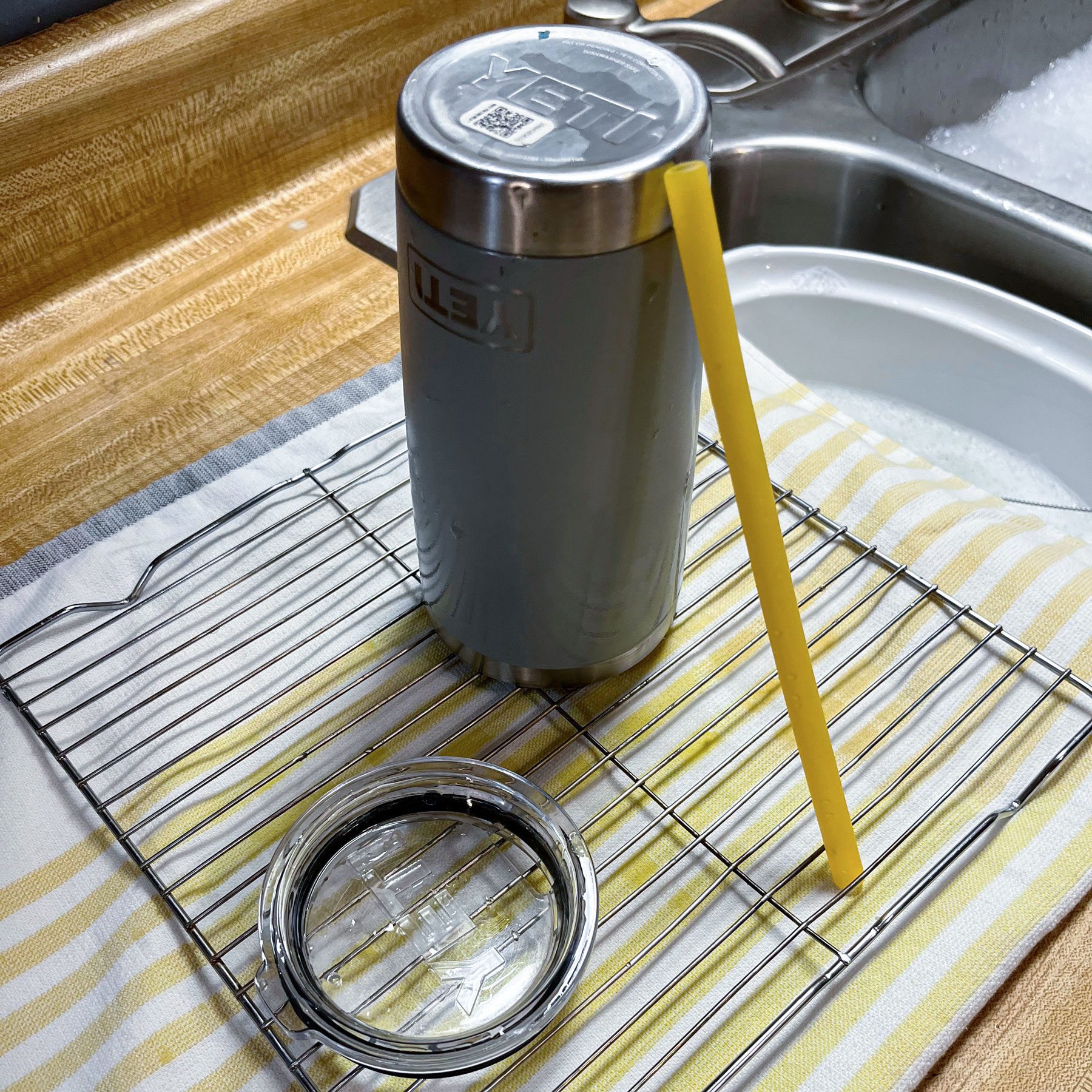 Water bottle straw and a bottle lid place on a surface for drying