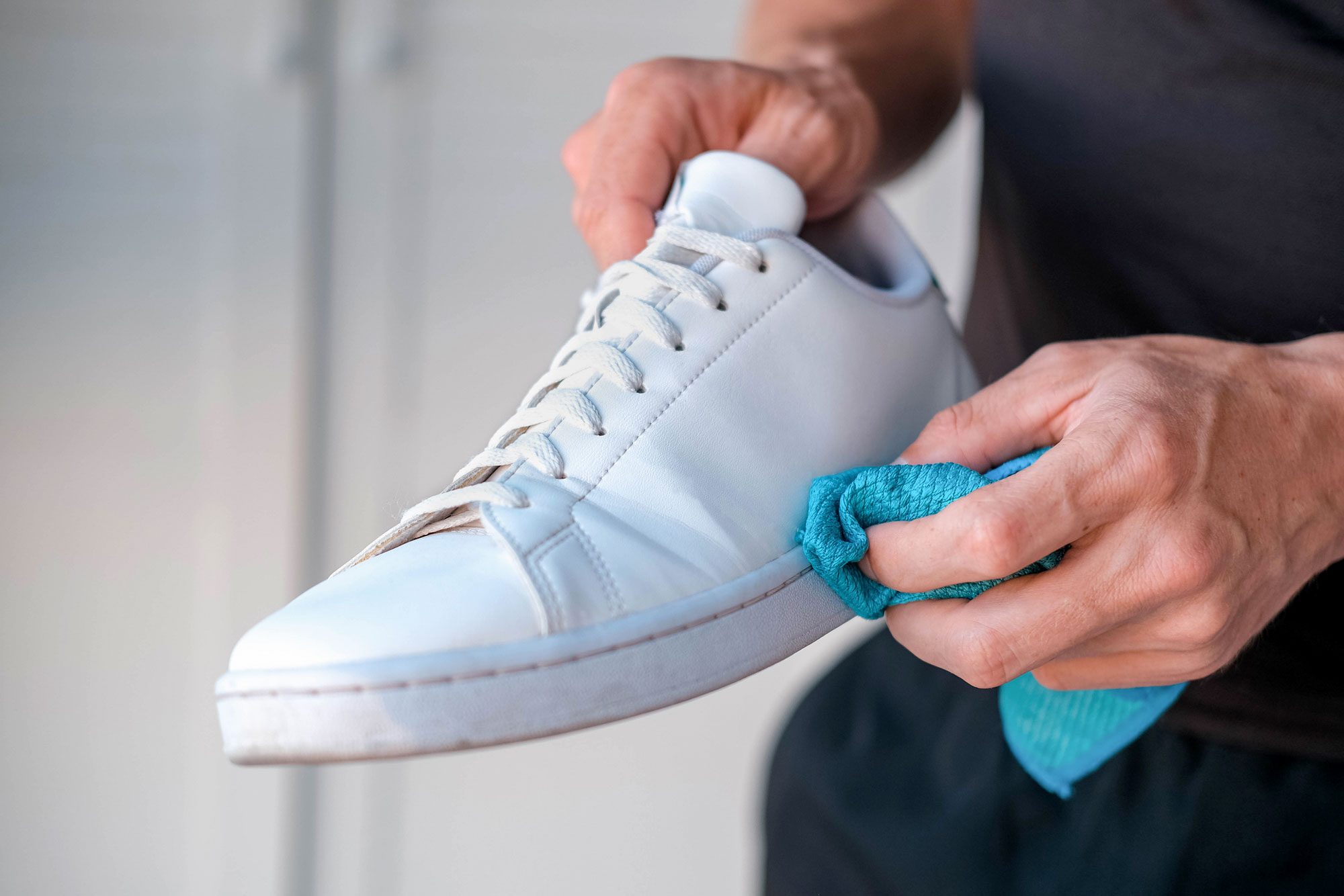A Man Cleans White Leather Sneakers From Dirt
