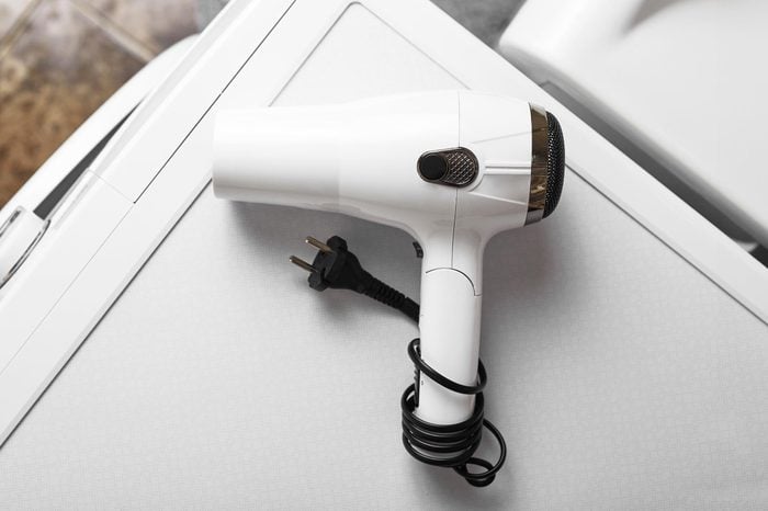 hair dryer on top of washing machine to remove wrinkles from clothes