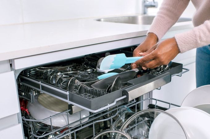 woman loading top rack of dishwasher
