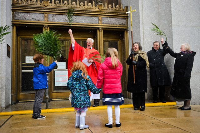 Trinity Lutheran Church members chant "Hosanna!" outside the courthouse during a Palm Sunday downtown procession on Sunday, March 25, 2018. Photo by Natalie Kolb