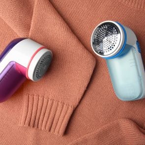 Modern fabric shaver on sweater with lint, flat lay