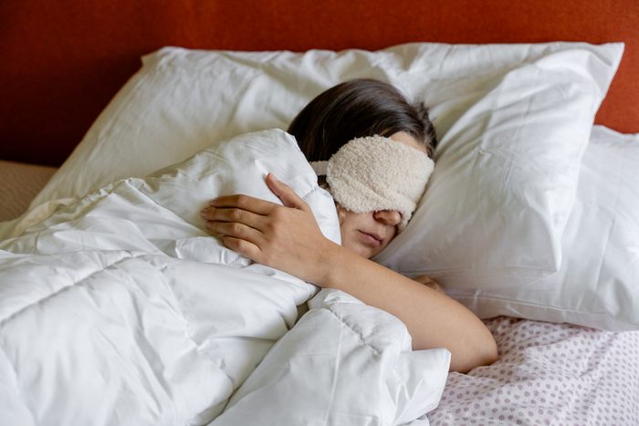 a woman sleeping with a Eye Sleep Mask on her head
