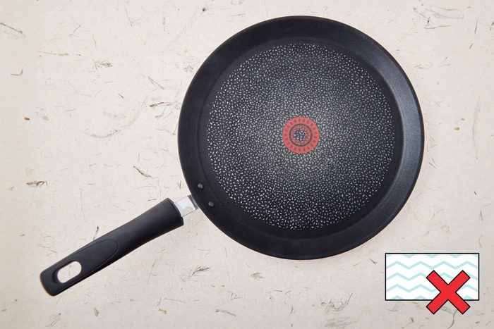 nonstick pan on a counter with a "no magic eraser symbol" in the corner