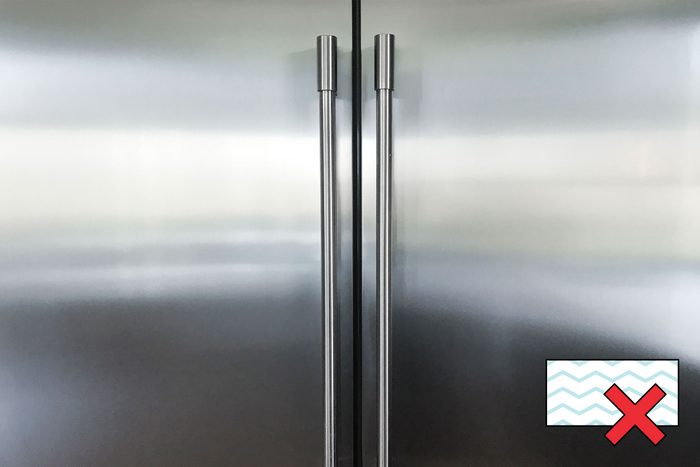 stainless steel fridge with a "no magic eraser symbol" in the corner