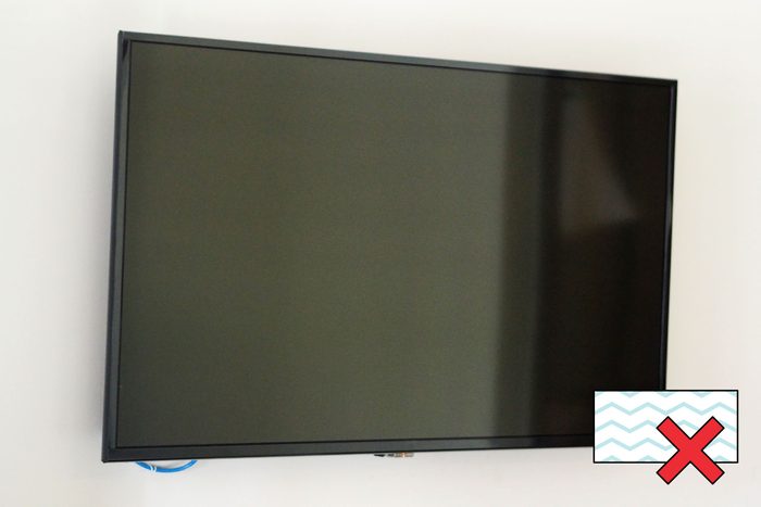 flat screen TV on wall with a "no magic eraser symbol" in the corner