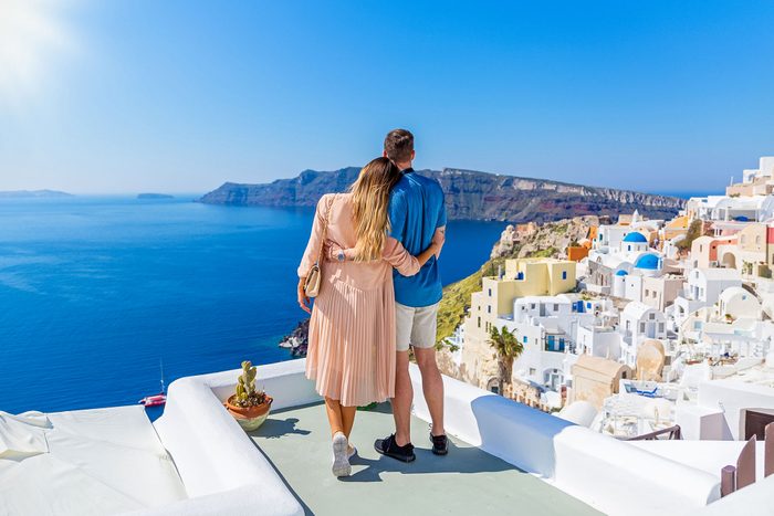 Young Couple On The Roof Of A Building In Santorini Greece