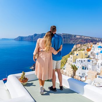 Young Couple On The Roof Of A Building In Santorini Greece