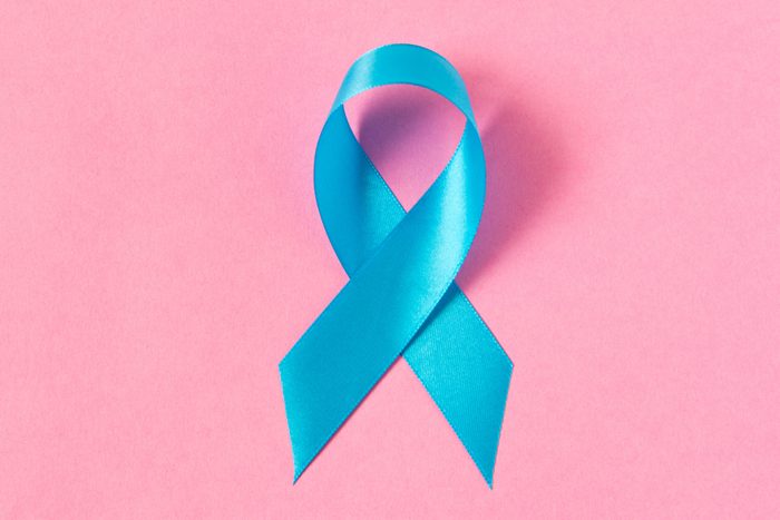 Blue ribbon. Isolated on pink background with empty space for text. Close up.