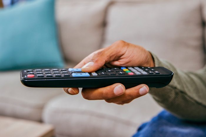 Shot of a man holding a remote control while watching TV