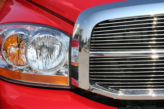 Front headlight and grill of a sporty red truck.