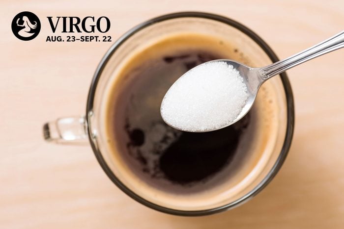 spoonful of salt going into coffee with virgo zodiac in upper left corner