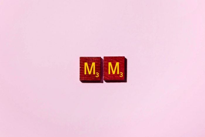 "MM" in scrabble letters on a pink background