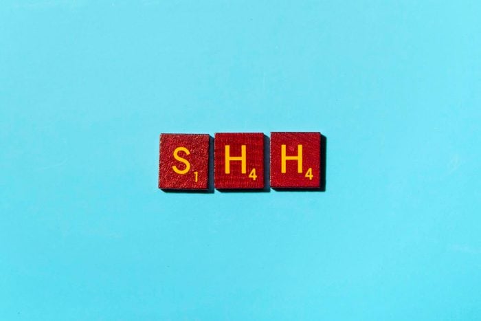 "SHH" in scrabble letters on a blue background