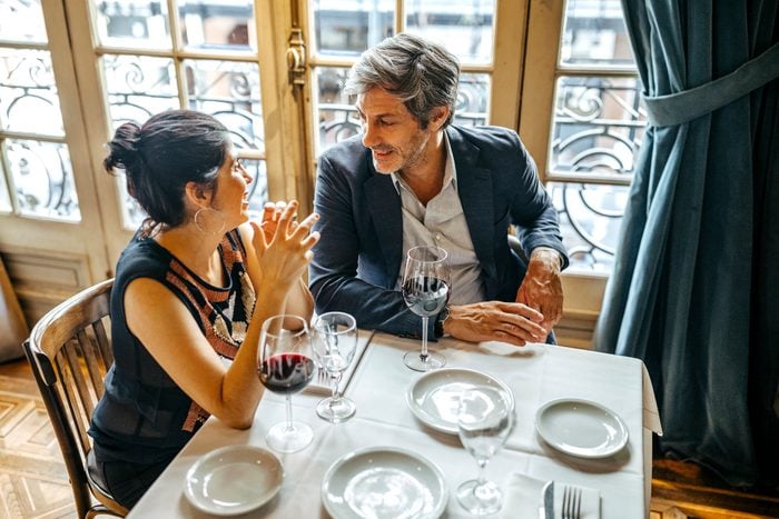 Mature couple flirting in restaurant along red wine