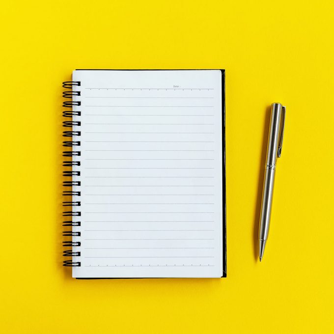 Note Pad and Pen on Yellow background