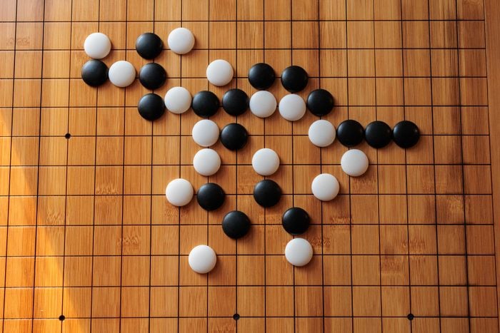 Wooden board with black and white play stones, game of go
