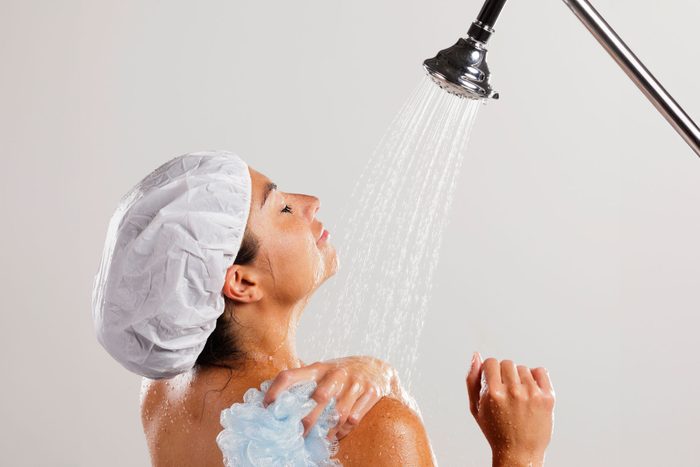 A dark-haired woman standing in a shower