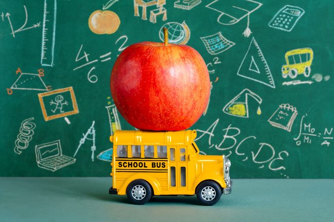 apple on a toy school bus with a chalkboard in the background
